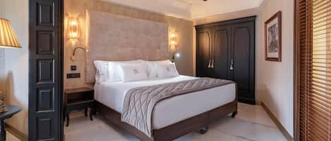 Une chambre à coucher comprenant un lit, un ventilateur de plafond, une table de chevet, une lampe fixée au mur et une armoire.