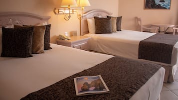 Due letti con testiere, un comodino, una lampada, una rivista sul letto e una sedia.