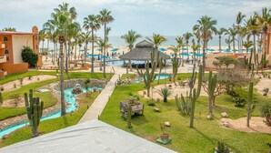 A resort with a pool, palm trees, and a beach view.