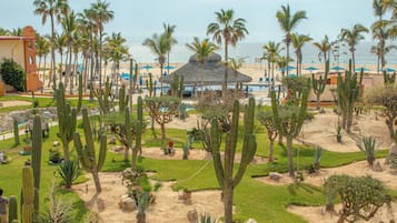 Un resort con piscina, palmeras y una playa al fondo.