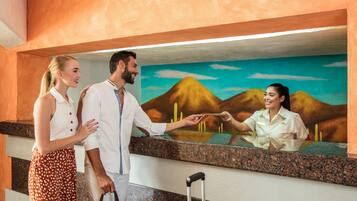 Zona de recepción con una recepcionista, un hombre y una mujer.