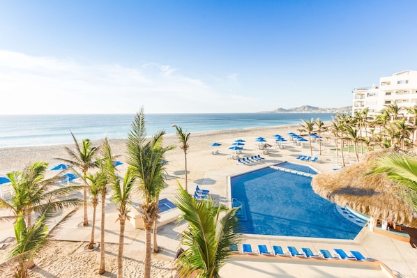 Una piscina al aire libre, sombrillas, tumbonas