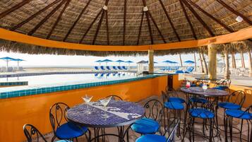 Una piscina al aire libre, sombrillas, sillones reclinables de piscina