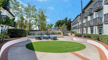 A courtyard with outdoor seating, a fire pit, and a well-maintained lawn.