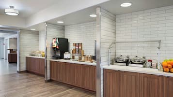 Una cocina moderna con armarios de madera, salpicadero de azulejos blancos y campana extractora de acero inoxidable.