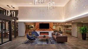 Uma sala de estar moderna com lareira, televisão de tela plana e móveis contemporâneos.