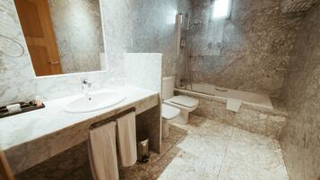 A bathroom with a marble sink, a toilet, and a shower.