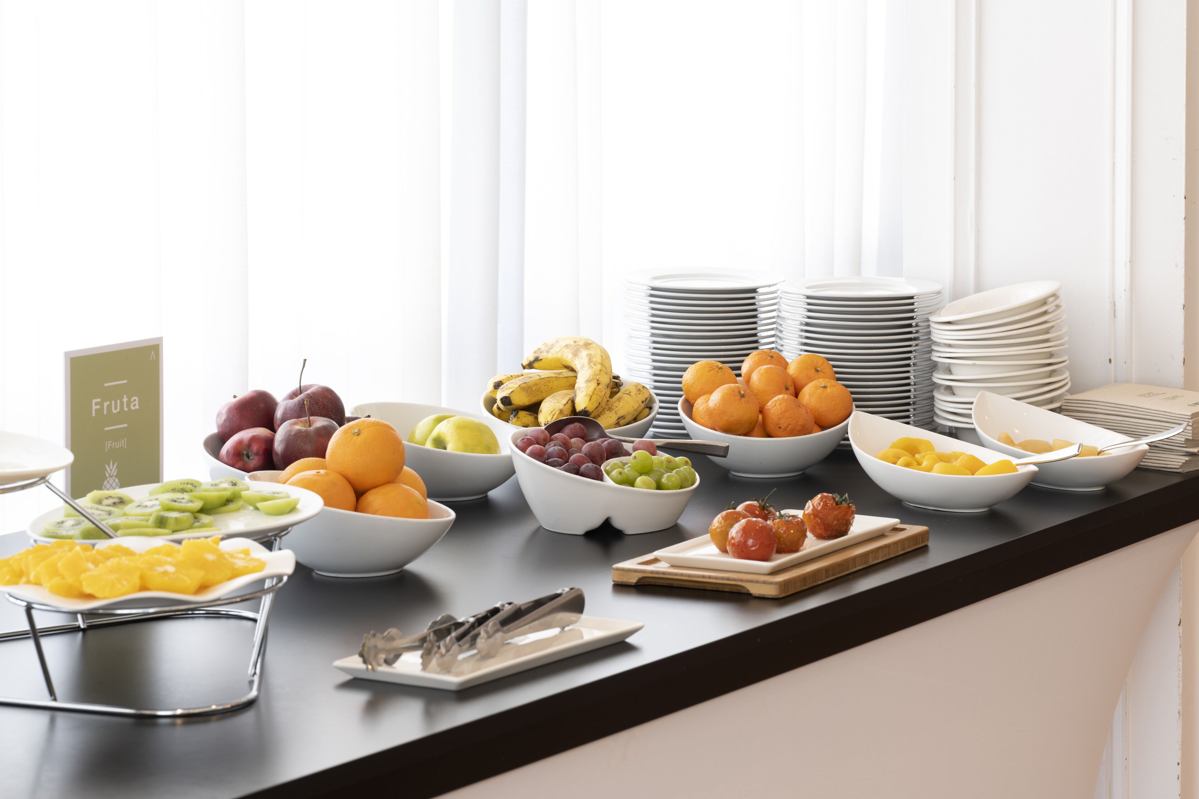 Un bufé de desayuno con diversas frutas y un cartel que dice 'Fruta'.