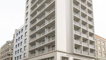 A multi-story hotel with a modern facade, a visible entrance, and a sign indicating it is a hotel.