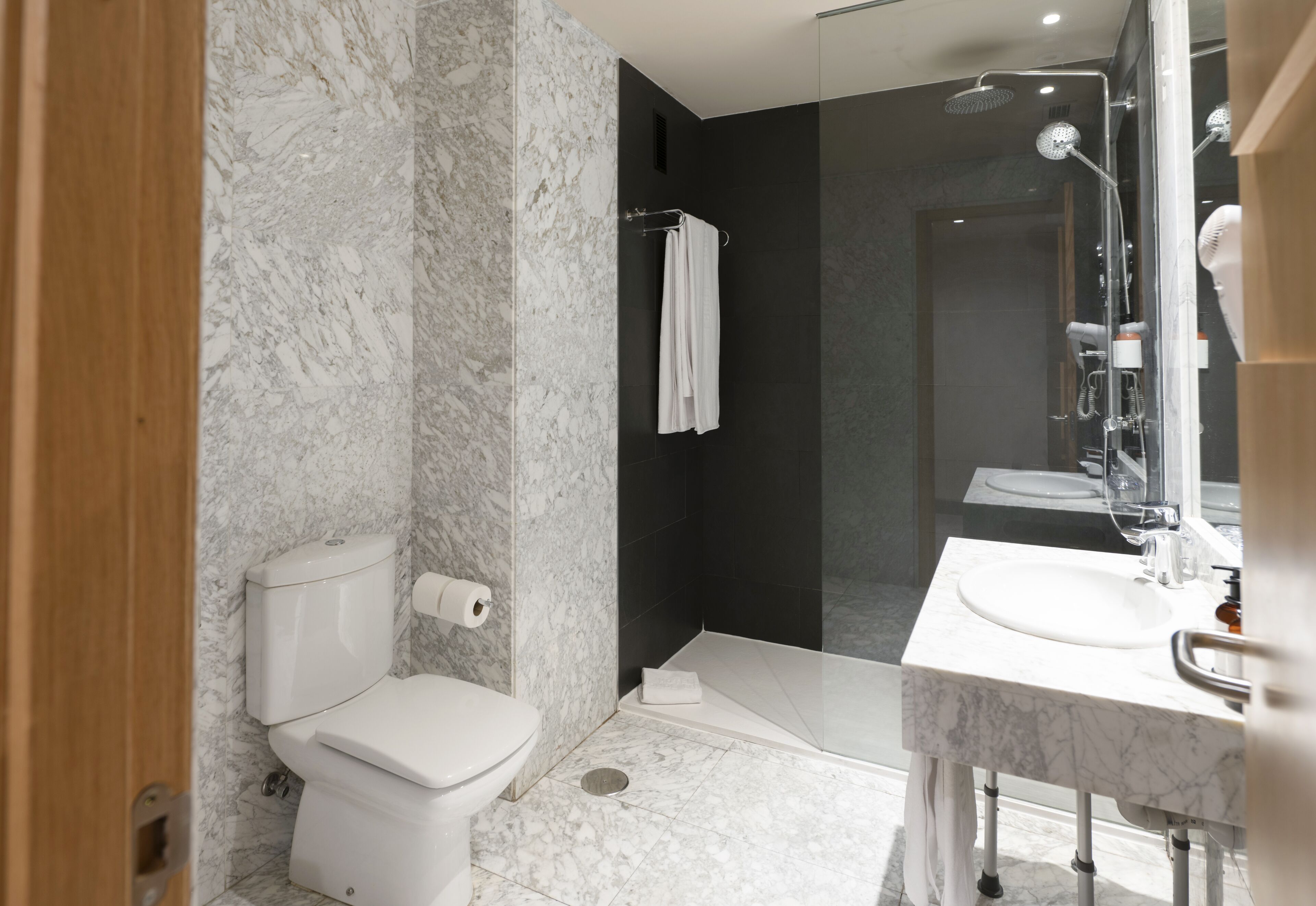 Une salle de bain moderne équipée de toilettes, d’une douche et d’un lavabo.