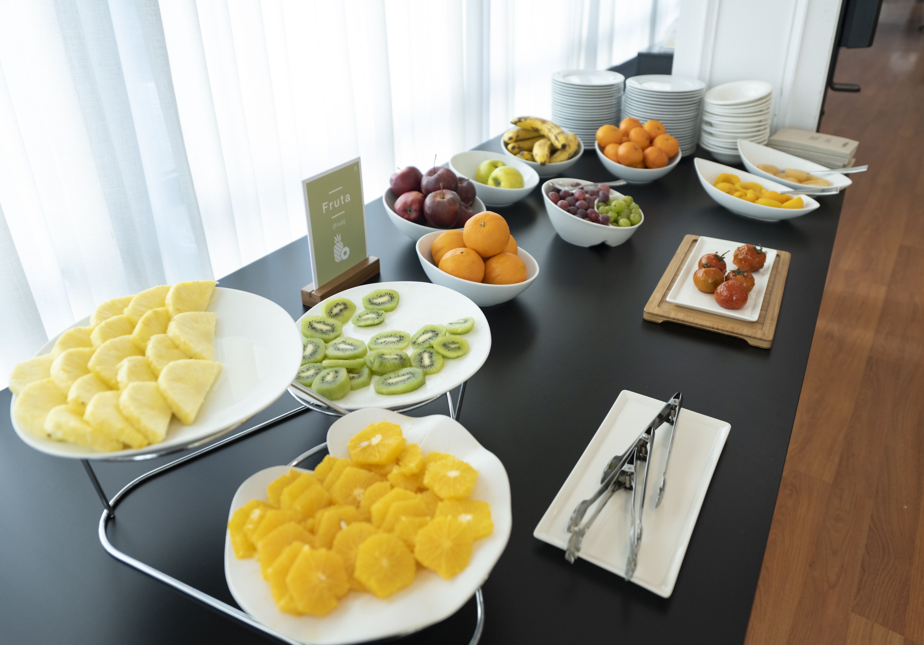 Un buffet de petit-déjeuner proposant divers fruits, avec un panneau indiquant « Fruits ».