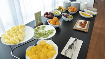 Un buffet de petit-déjeuner proposant divers fruits, avec un panneau indiquant « Fruits ».