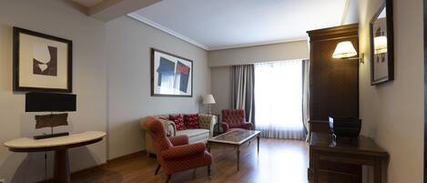 Amplia sala de estar con sofá, sillones, una mesa de centro y un mueble para televisión.