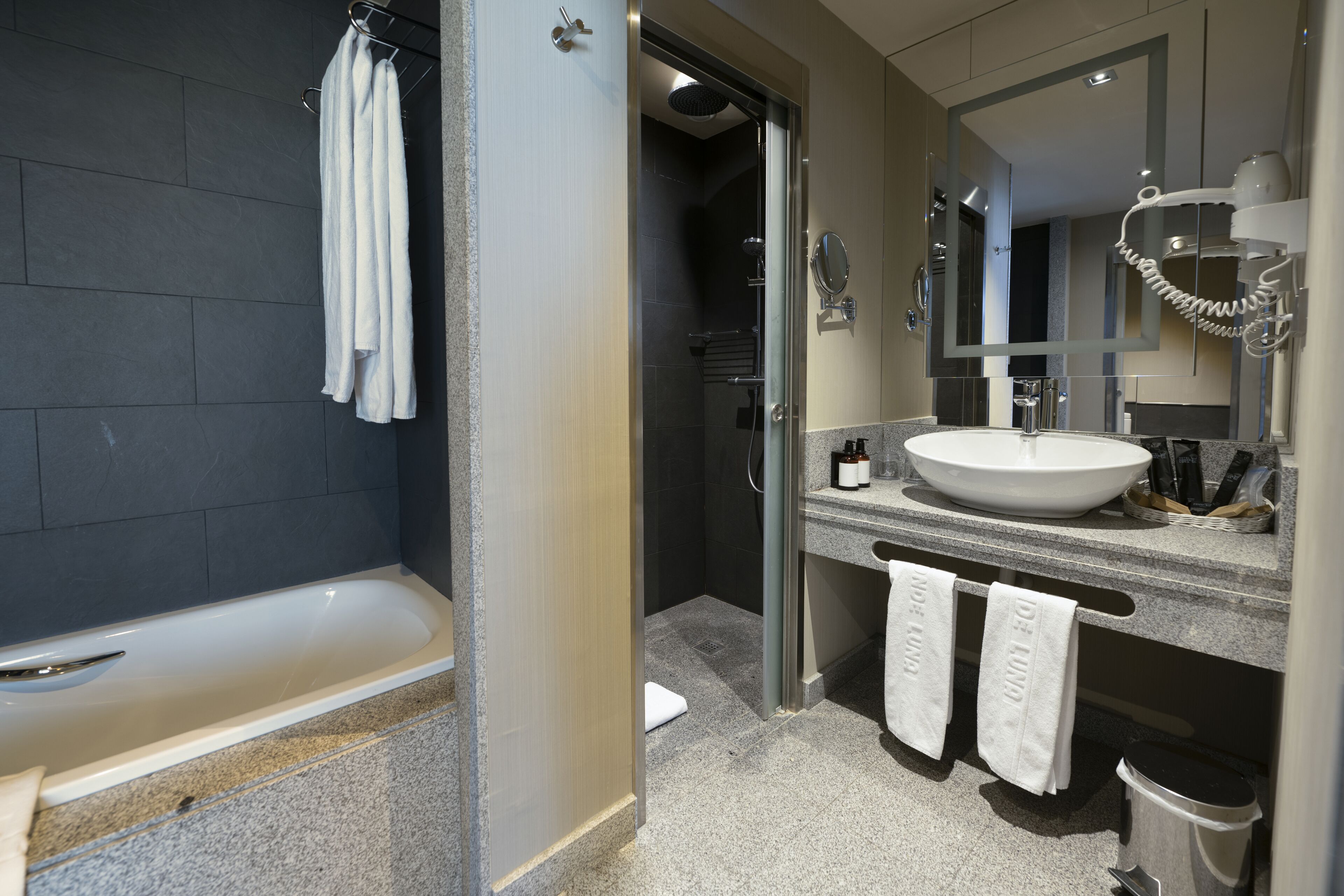 A modern bathroom with a bathtub, a sink, and a shower.