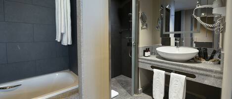 A modern bathroom with a bathtub, a sink, and a shower.