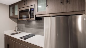Una cocina moderna con electrodomésticos de acero inoxidable, un lavamanos doble y armarios de madera.