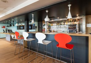 A bar area with stools, a counter, and various bottles. - B&B HOTEL Lyon Eurexpo Bron (Bron)