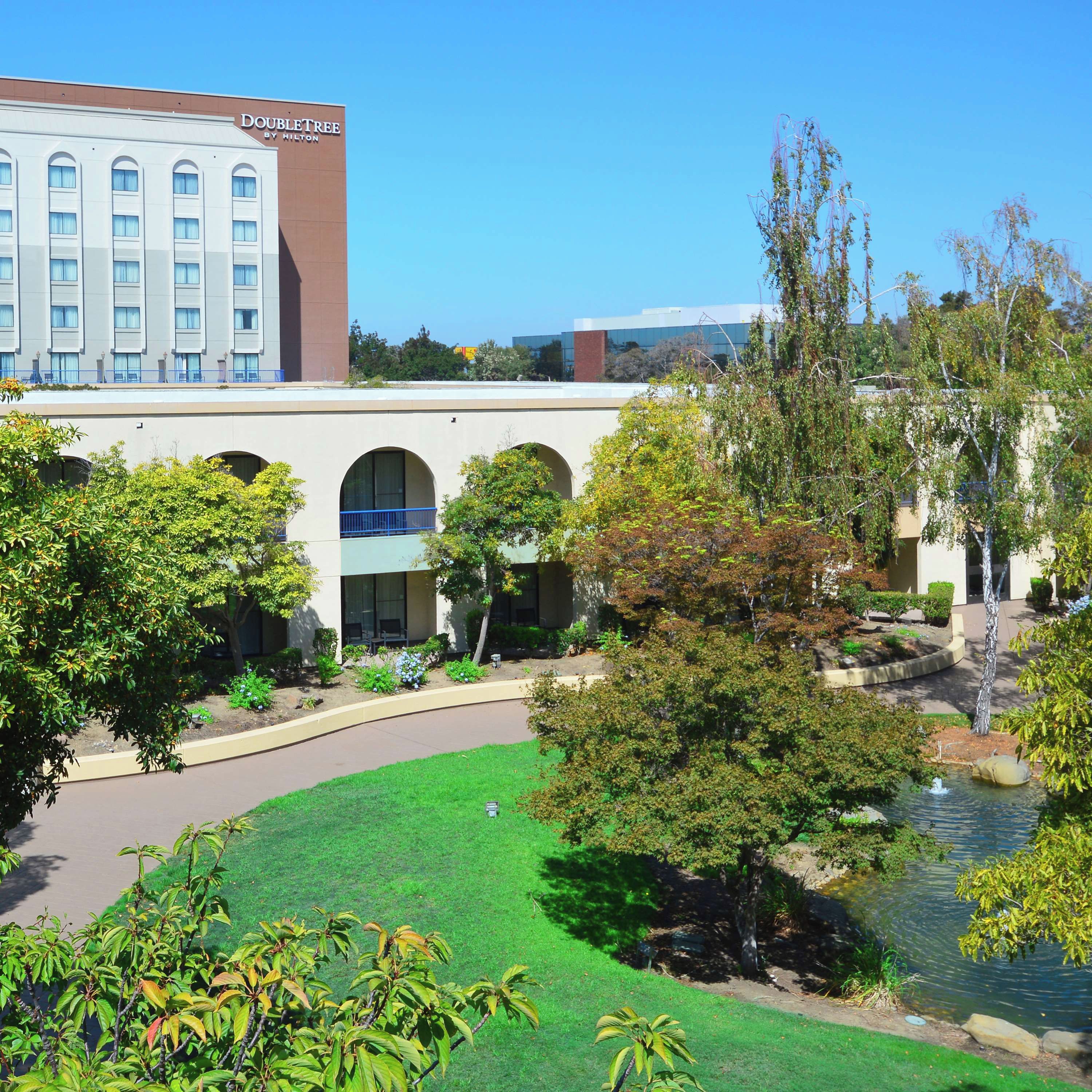 A hotel with a courtyard, a fountain, and a pool.