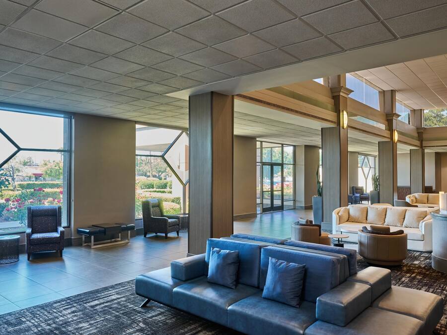 A spacious lobby with a large seating area, a view of the outdoors, and a modern architectural design.