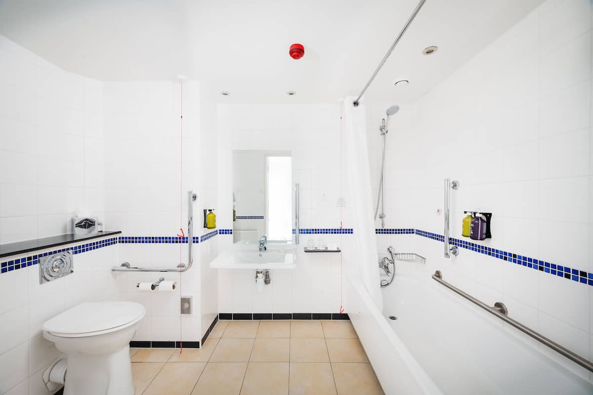A modern bathroom with a toilet, sink, and bathtub.