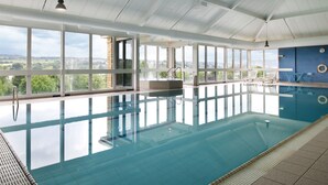An indoor swimming pool with clear views of the surrounding landscape through large windows. - Holiday Inn Brighouse by IHG (Brighouse)