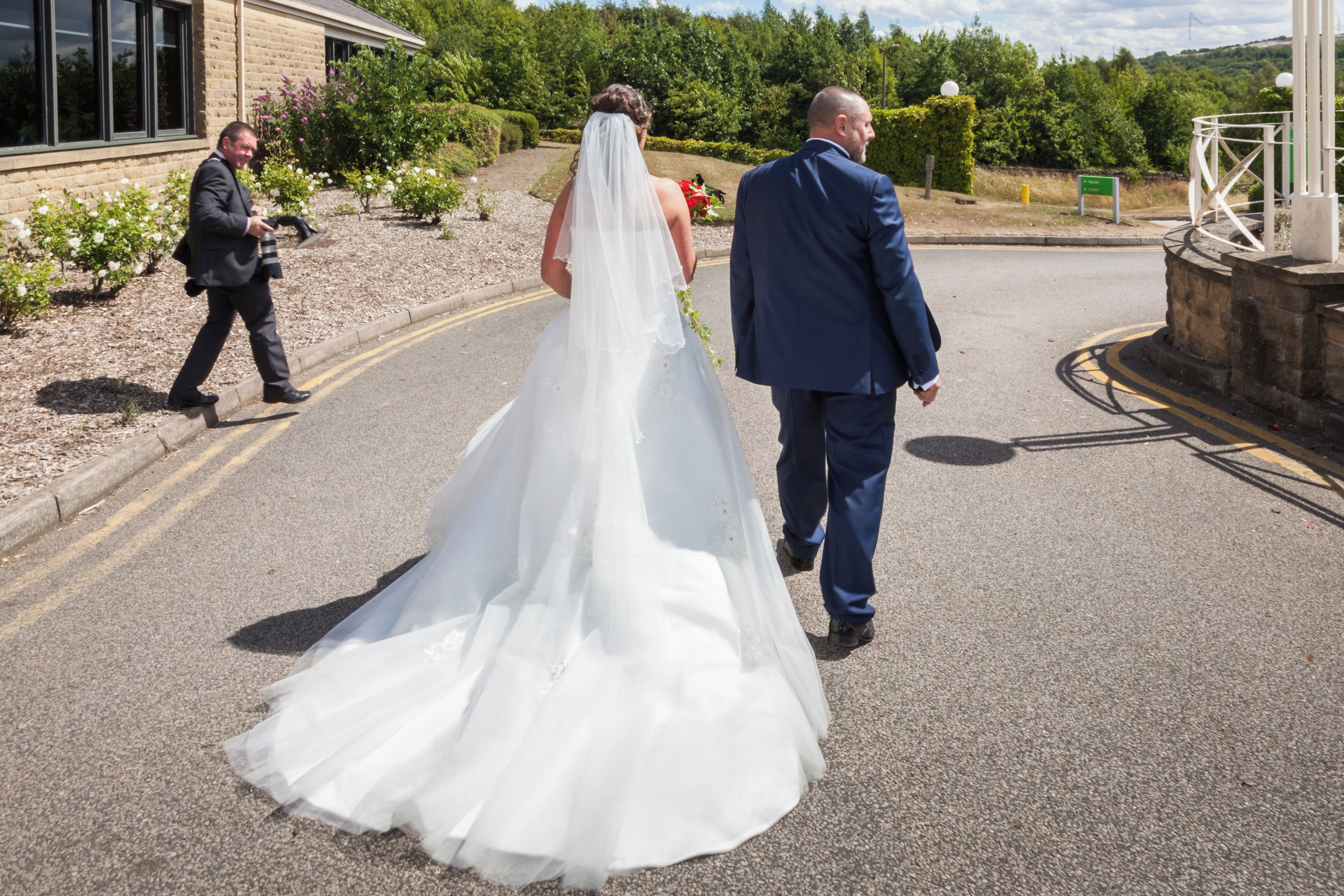 A bride and groom walking down a road.