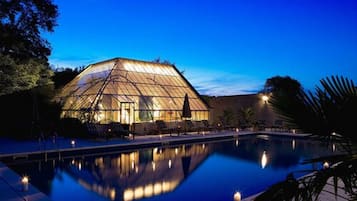 Una piscina al aire libre de temporada, sombrillas