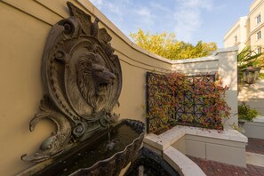 Stunning fountain and lush garden adorn the exterior of this beautifully designed building.
