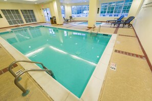 Relax by the pool surrounded by comfortable lounge chairs and a scenic view.