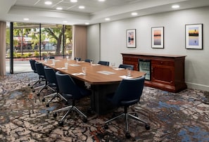 A conference room with a long table, chairs, and a fireplace.