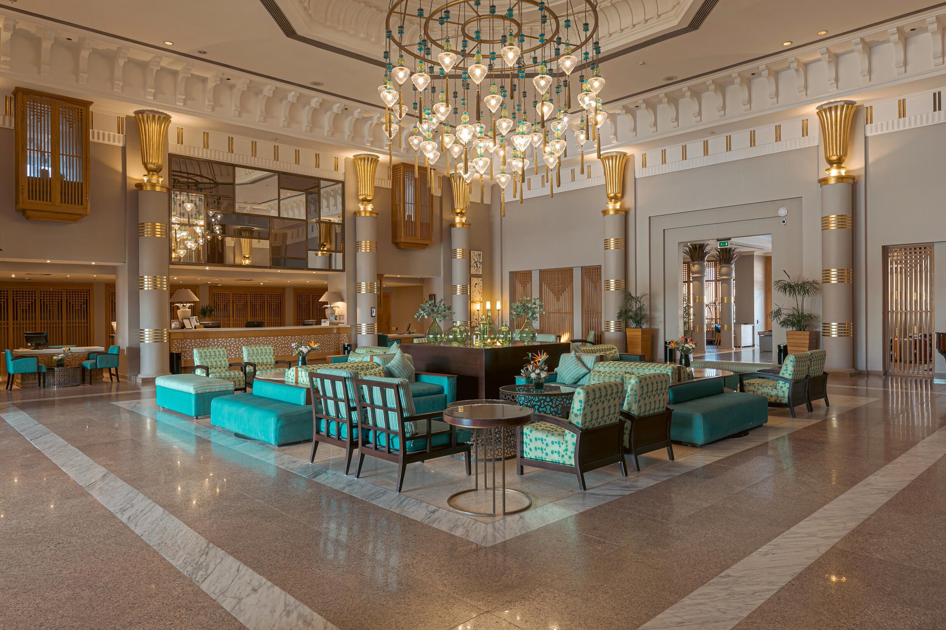 Eine geräumige Lobby mit einem prunkvollen Kronleuchter, Sitzgelegenheiten und einer Rezeption.