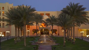 A hotel entrance with a fountain, palm trees, and a well-lit pathway. - Continental Hotel Hurghada (Hurghada)
