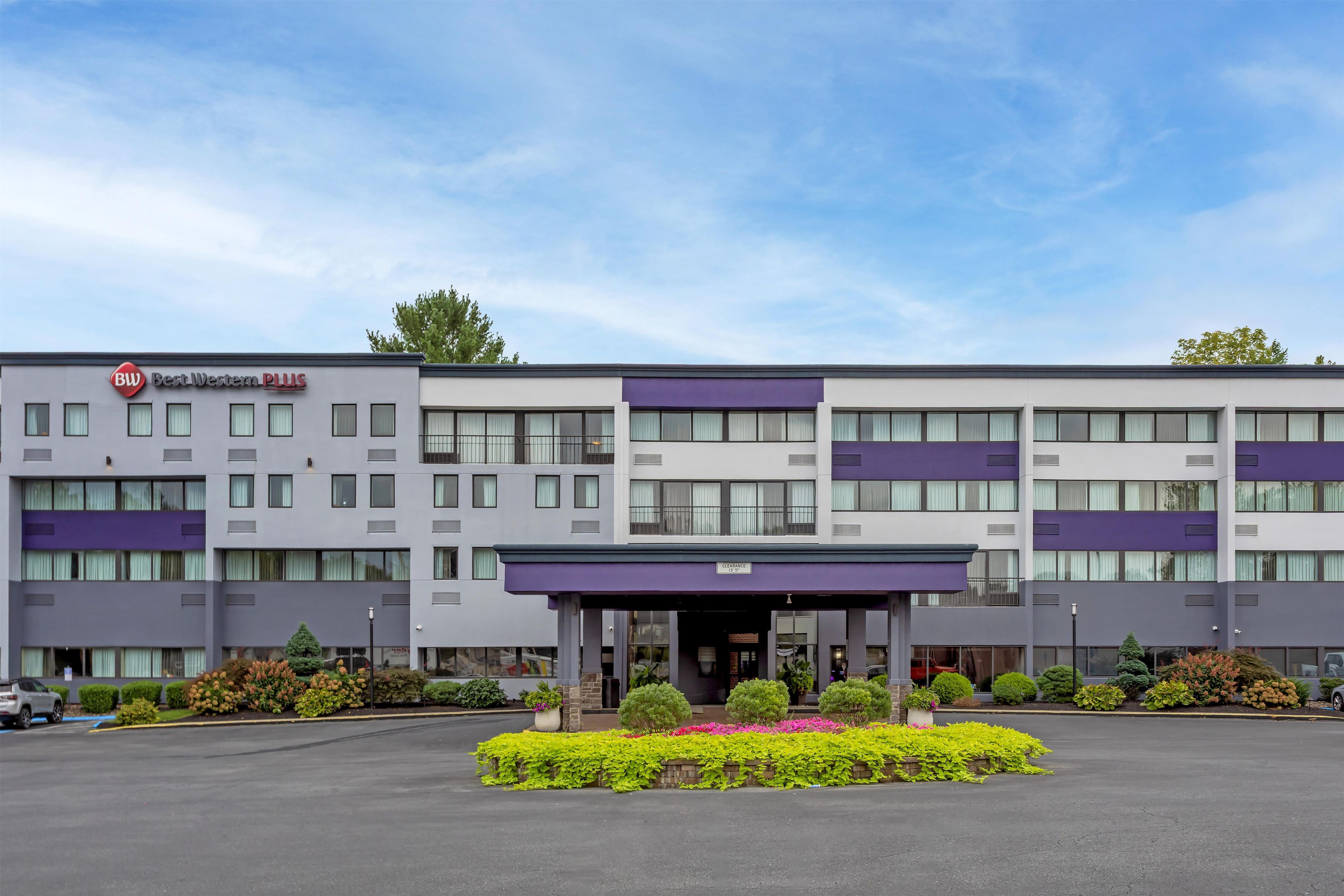A multi-story hotel with a modern facade, a clear entrance, and a parking lot.