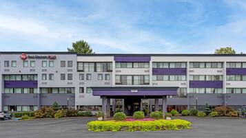 A multi-story hotel with a modern facade, a clear entrance, and a parking lot.