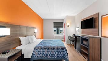 Una habitación de hotel moderna con una cama, un escritorio, una televisión y vistas al exterior.