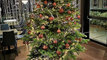 A Christmas tree with ornaments in a hotel lobby.