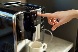 Enjoy a convenient coffee experience with our in-room coffee machine, featuring a touch interface and easy access to a water reservoir.