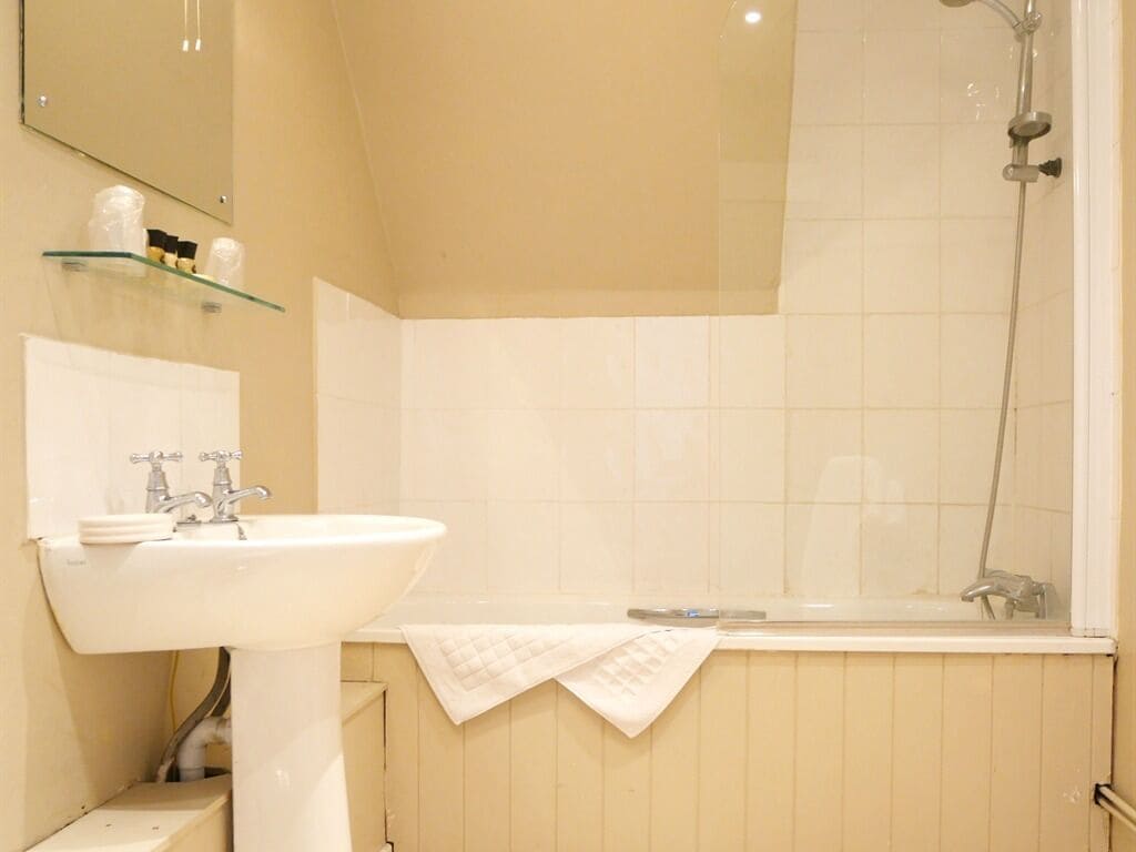 Un bagno con lavandino, specchio e doccia.