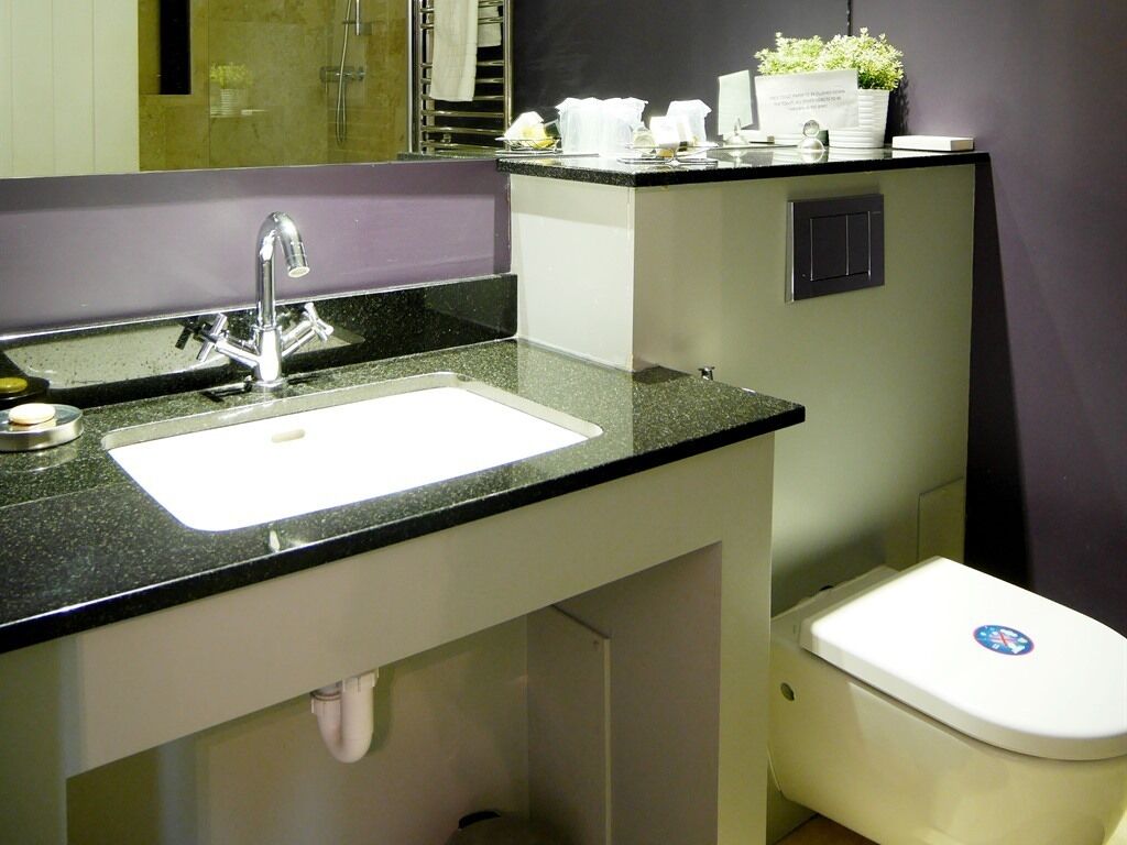 A bathroom with a sink, mirror, and toilet.