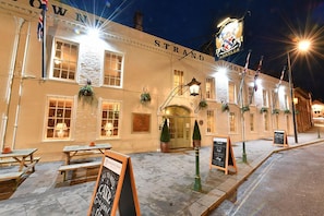 A historic hotel with a classic facade, outdoor seating, and a prominent sign.