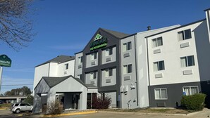 Un hotel Wingate con diseño moderno, que destaca por su letrero llamativo, amplias ventanas y un estacionamiento.