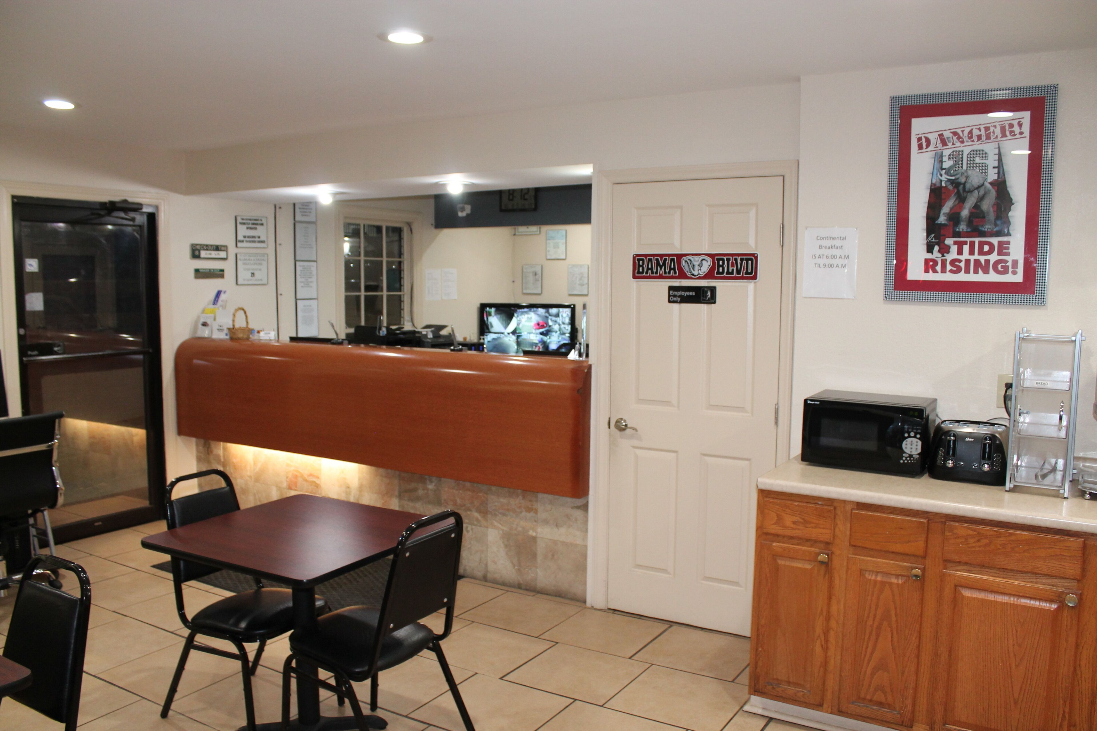 A restaurant with a counter, seating area, and kitchen.