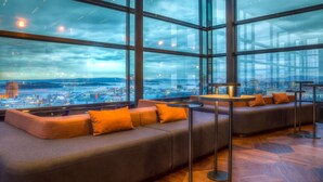 Un salón moderno con un amplio ventanal que ofrece vistas a la ciudad.