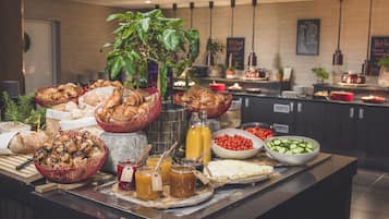 A buffet with various food items, including pastries, fruits, and condiments.