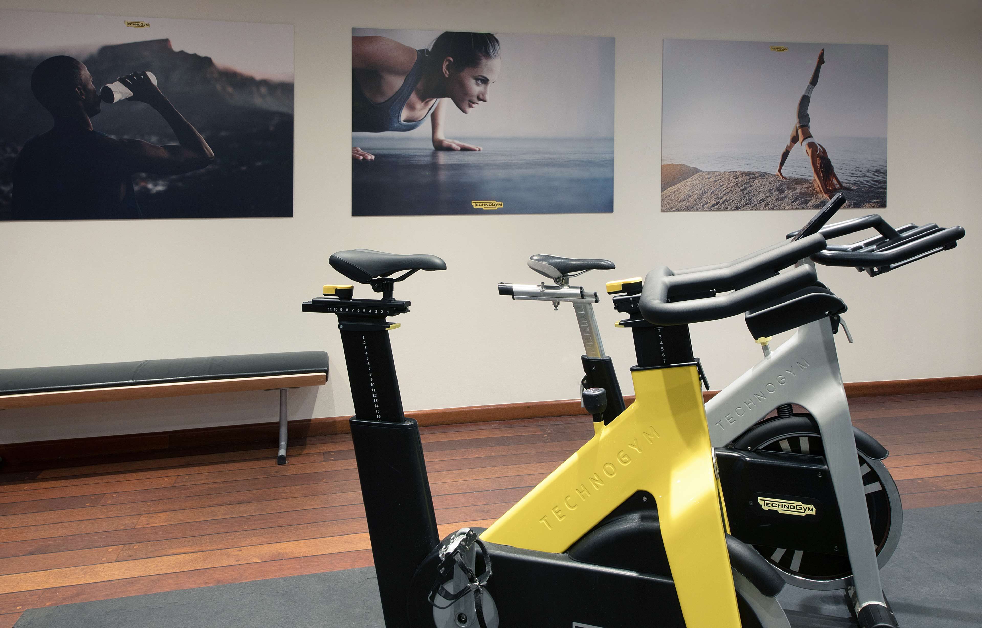 Gimnasio interior con bicicletas estáticas, banco y equipo de ejercicios.