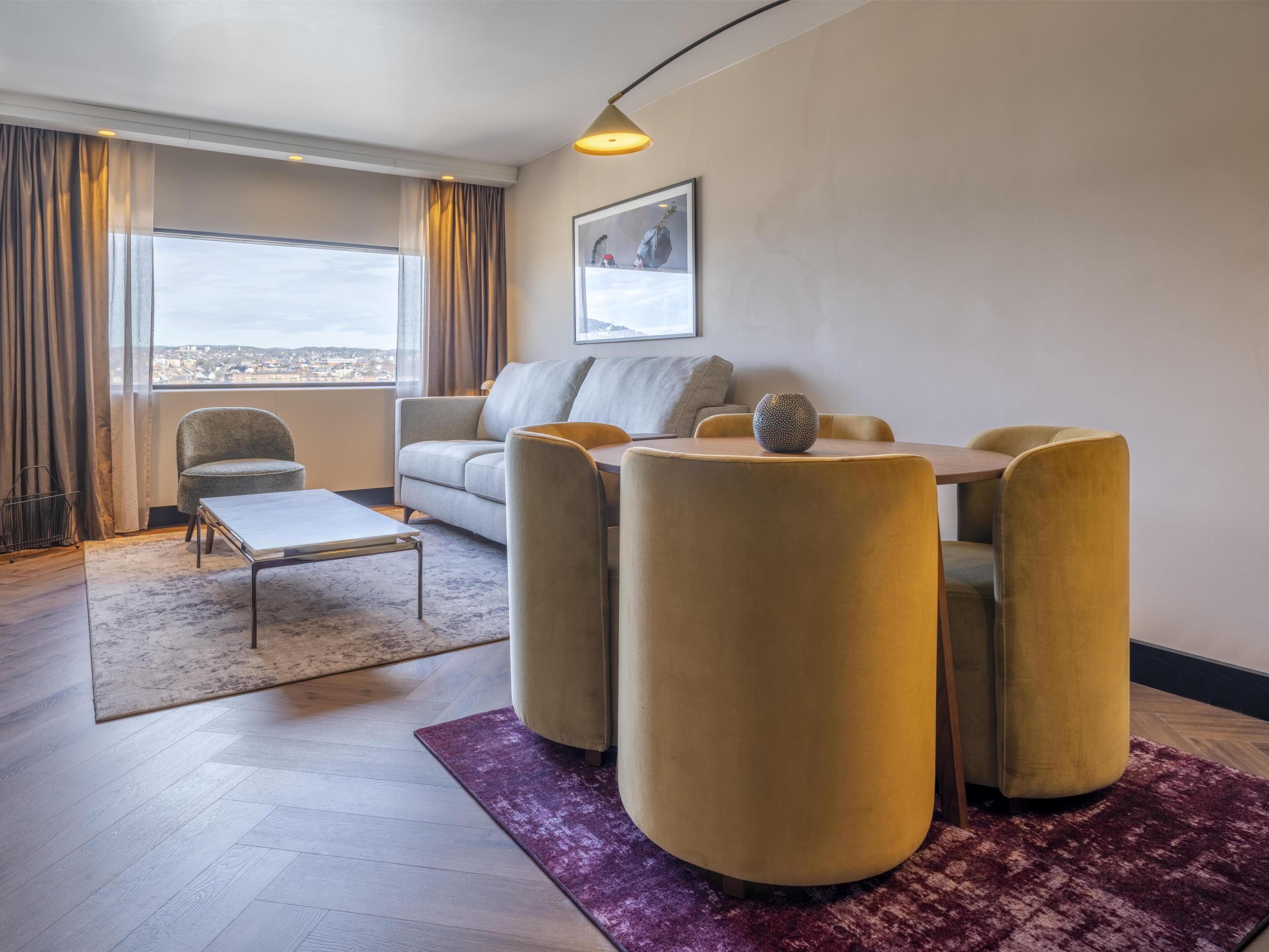 Una sala de estar moderna con un sofá, una mesa de centro y un comedor con sillas.