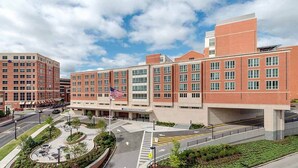 A multi-story medical center with a central courtyard, parking area, and a flagpole with an American flag. - Comfort Inn Glenmont - Albany South (Glenmont)