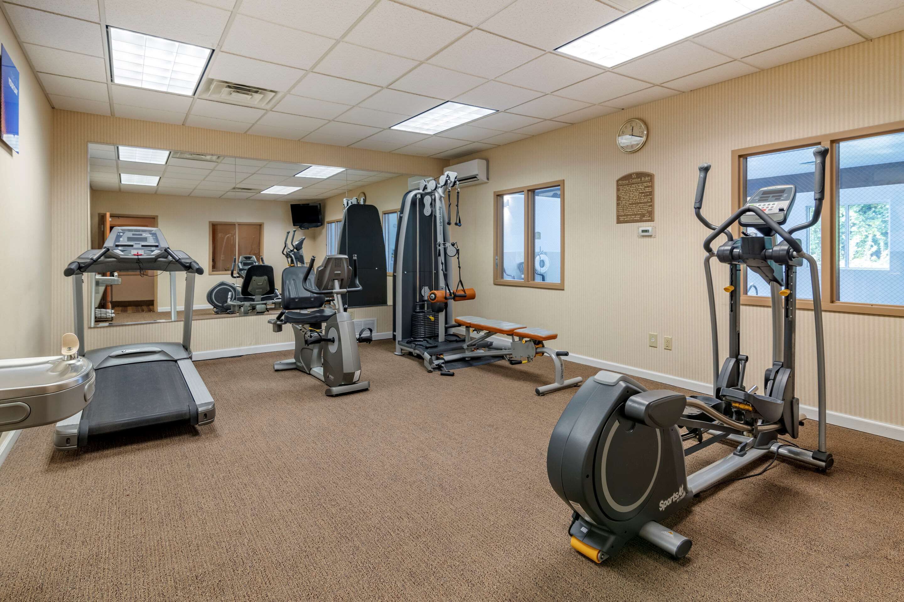 A gym with treadmills, elliptical machines, and weight equipment.