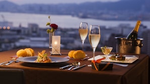 Una mesa dispuesta para comer, con vistas a la ciudad y al agua.