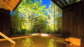 Una piscina interior tranquila con bancos de madera y vistas a exuberante vegetación.